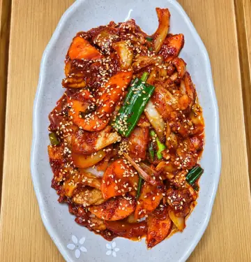 흰 접시에 담긴 매콤한 제육볶음